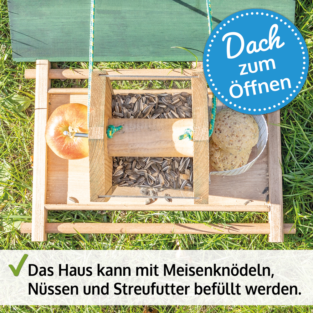 Vogelhaus Bird Kitchen Braun mit geöffnetem Dach, von oben fotografiert, befüllt mit Meisenknödeln, Nüssen und Streufutter