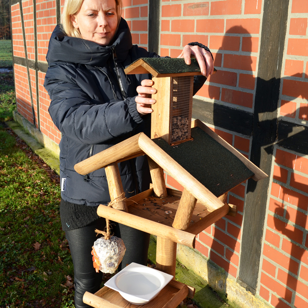 Das rustikale Vogelhaus Bird Farm mit praktischem Ständer, ideal für die Vogelfütterung im natürlichen Gartenumfeld