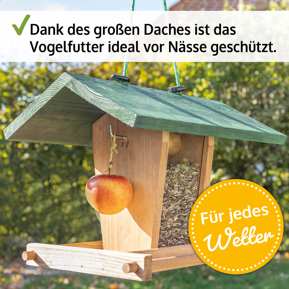 Vogelhaus Bird Kitchen mit großem grünem Dach das das Vogelfutter vor Nässe schützt an der Seite hängt ein Apfel geeignet für jedes Wetter